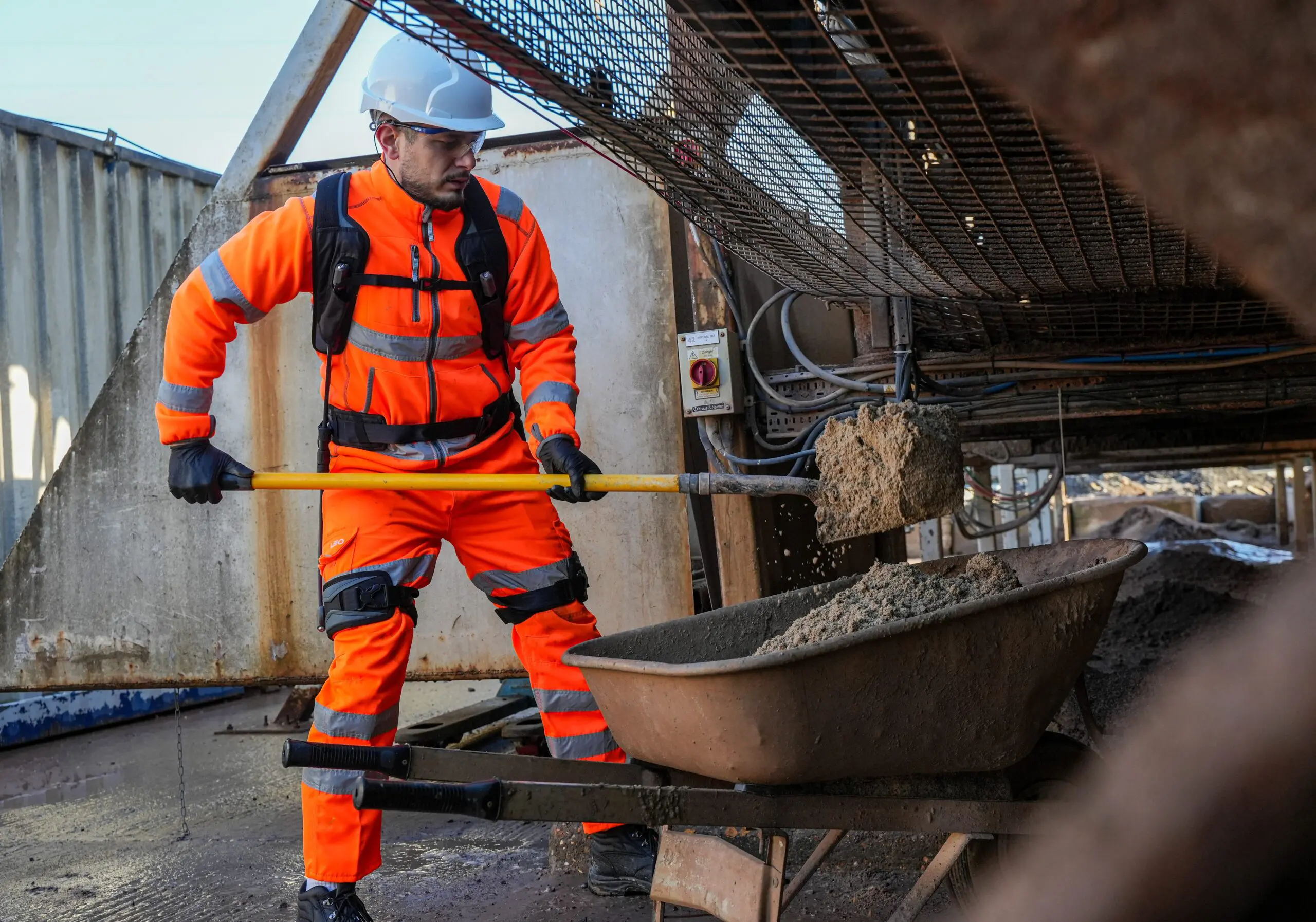 Construction exoskeleton supporting manual material lifting on a building site
